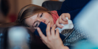 Eine Frau liegt krank im Bett (Symbolbild): Die telefonische Krankschreibung wurde dauerhaft eingeführt.