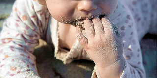 Baby isst Sand
