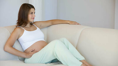 Schwangere Frau entspannt sich auf dem Sofa