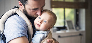 Vater mit Baby im Arm
