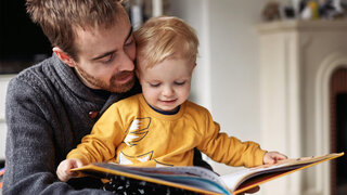 Vater liest mit kleinem Sohn