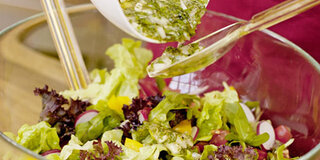 Salatdressing über Salat gießen