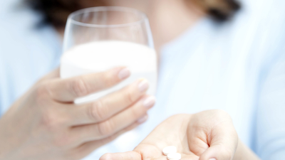 Frau nimmt Medikament mit Milch ein