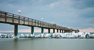 Bizarre Eisformationen umhüllen die Seebrücke bei Prerow auf dem Darß