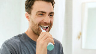 Mann putzt sich die Zähne