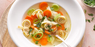 Suppe mit Pfannkuchen-Streifen und Gemüse.