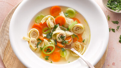 Suppe mit Pfannkuchen-Streifen und Gemüse.