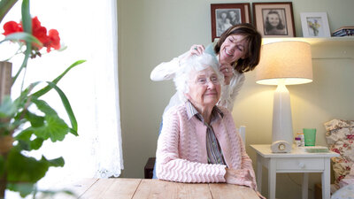 Frau kümmert sich um eine Seniorin