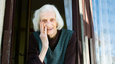 Seniorin Uralt Alter 90 bis 100 jahre alt aus Fenster Schauen Fröhlich zufrieden Jung aussehend Bescheiden Falten 