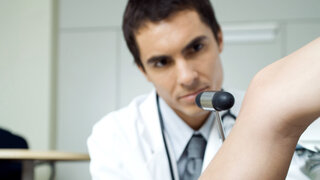 Test mit dem Reflexhammer: Der Arzt prüft, wie bestimmte Nerven und Muskeln reagieren.
