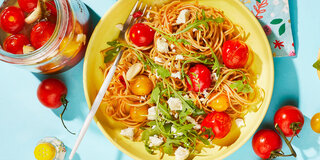 Spaghetti mit marinierten Tomaten und Rucola.