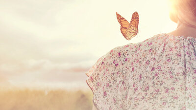 Frau in der Sonne mit Schmetterling