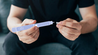 Eine Fotomontage zeigt einen Mann, der einen stilisierten Insulin-Pen in der Hand hält.