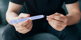 Eine Fotomontage zeigt einen Mann, der einen stilisierten Insulin-Pen in der Hand hält.