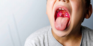 Eine Fotomontage zeigt einen Jungen, der seinen Mund weit öffnet und zwei comicartige Gestalten feixen in seinem Hals.
