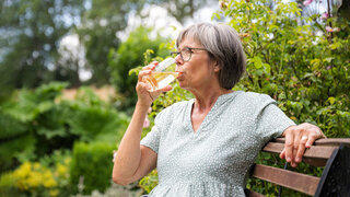 Eine Frau trinkt aus einem Glas.