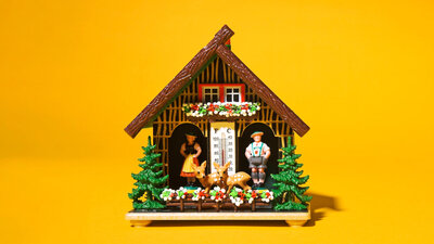 Ein traditionelles Wetterhäuschen mit zwei Figuren, einem Mann und einer Frau, die je nach Wetterlage aus dem Häuschen heraustreten.