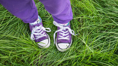 Mit Schuhen und langer Hose im Gras