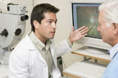 Der Augenarzt zeigt dem Patienten, wie die Netzhaut aussieht