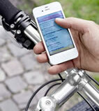 Radfahrer sucht mit seinem Smartphone und Apotheken-App eine Apotheke 