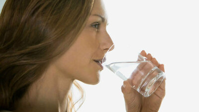 Frau trinkt ein Glas Wasser
