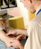 Der Arzt untersucht das verletzte Gelenk  oft reicht das, um die Diagnose Bänderriss stellen zu können