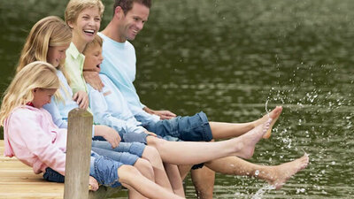 Familie lässt die Beine im Wasser baumeln