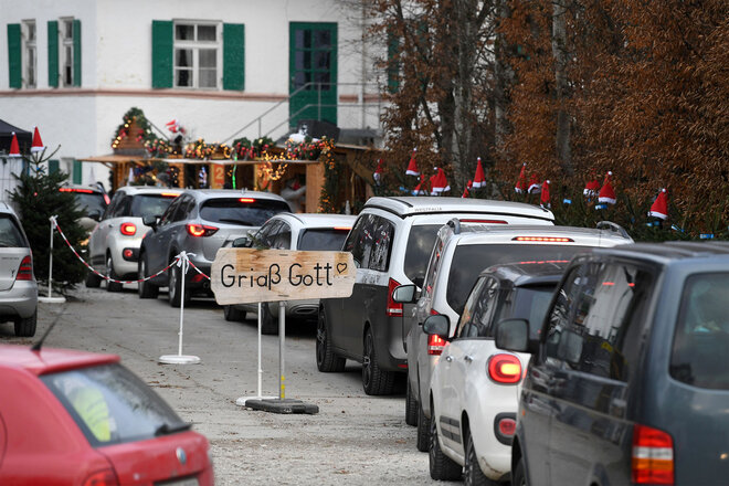 Autos stehen in einer Schlange auf einem Weihnachtsmarkt 