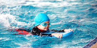 Gut ausgestattet? Neopren-Anzüge sind für unsichere Schwimmer:innen nicht empfehlenswert. Badekappen hingegen stören nicht beim Schwimmen, halten aber warm.